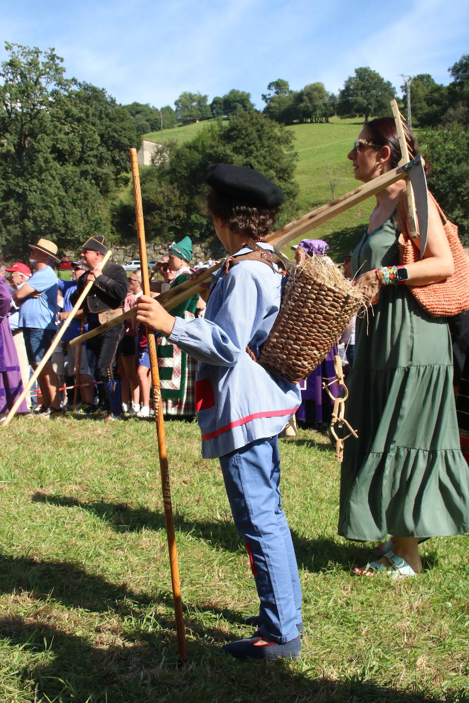 Niño vestido con ropa de trabajo y utensilios del campo.