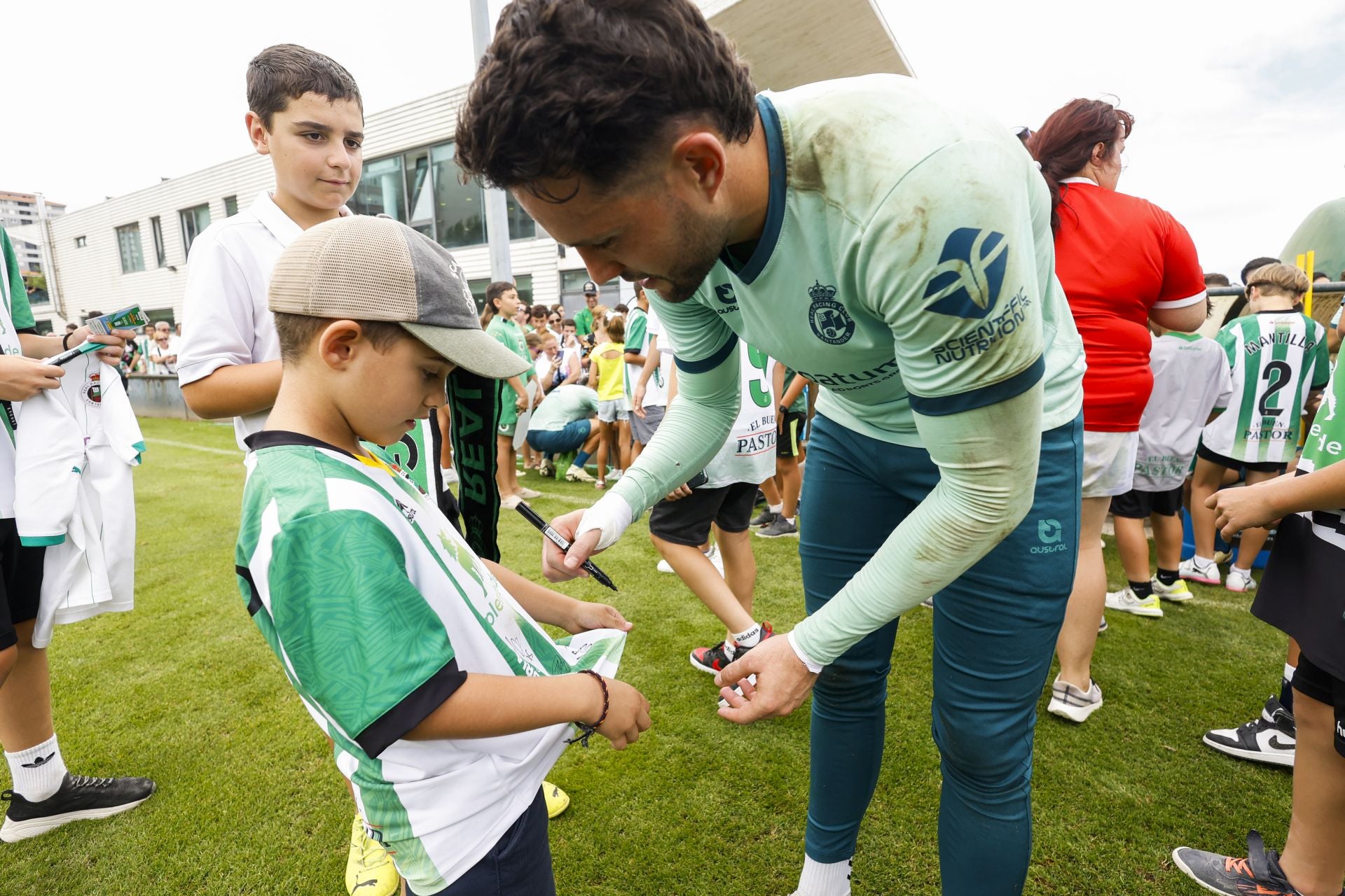 Parera pone su autógrafo en la camiseta de un chaval que recolectaba autógrafos de los verdiblancos.