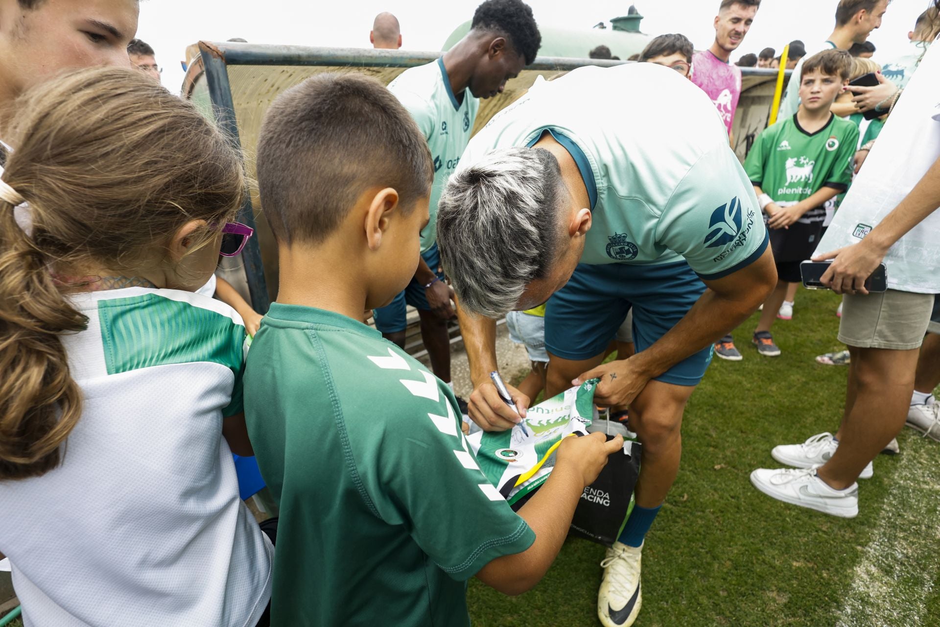 Arana firma la camiseta a un pequeño racinguista.