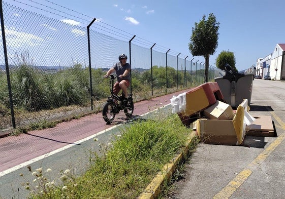 En un tramo del carril bici de Raos, un ciclista se topa con basura abandonada.