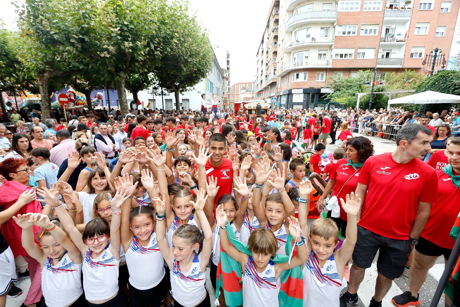 Mohamed Attaoui acompañado de participantes de la Escuela Municipal de Atletismo, este domingo, abriendo la Gala Floral.