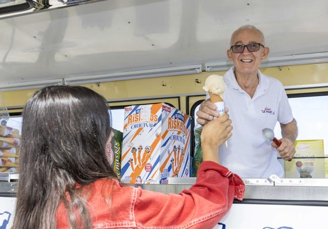 Omar sirviendo un helado a una clienta.