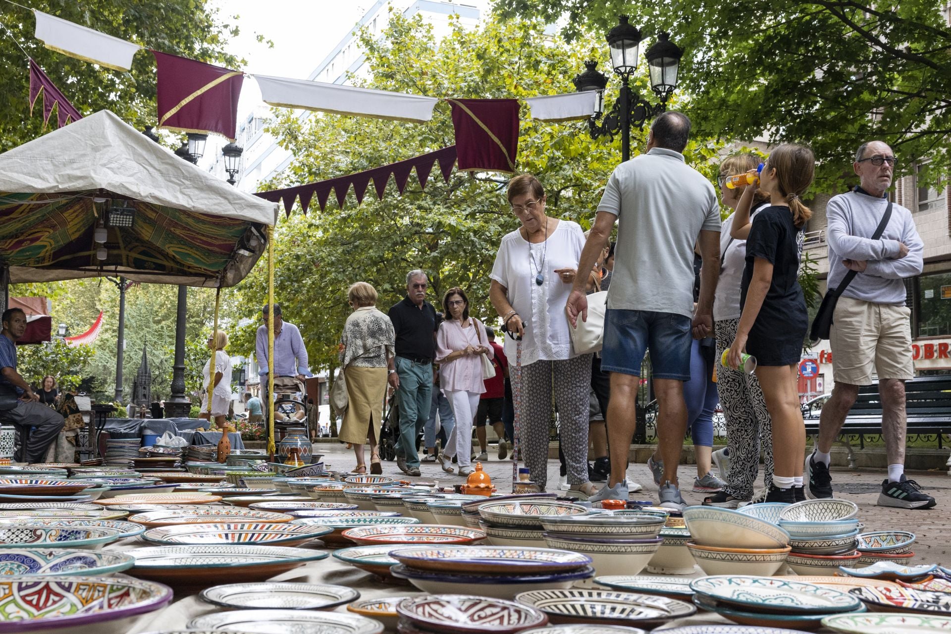 Una mujer contempla los platos artesanales expuestos en la calle.