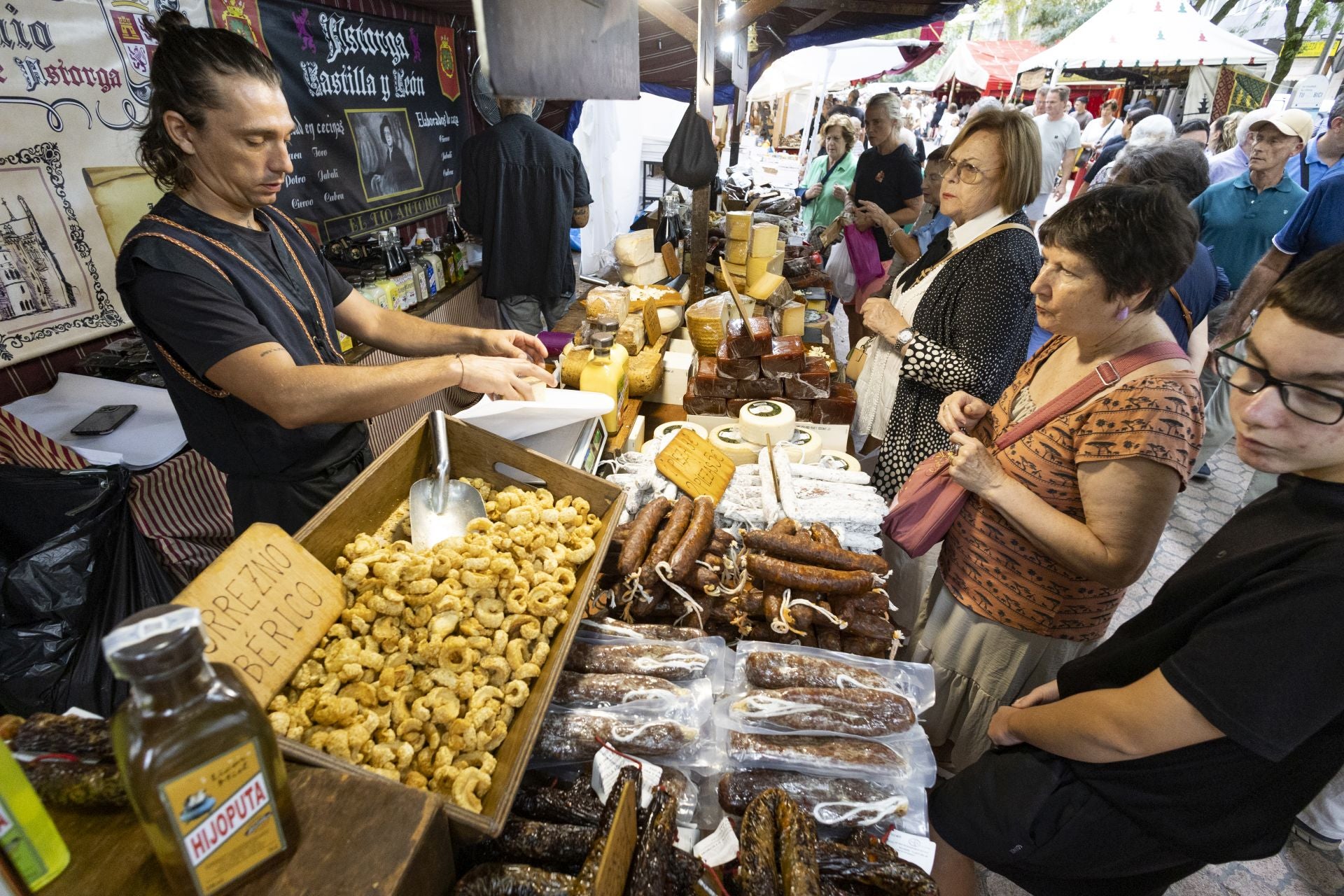 Compradores en un puesto de embutidos del mercado.