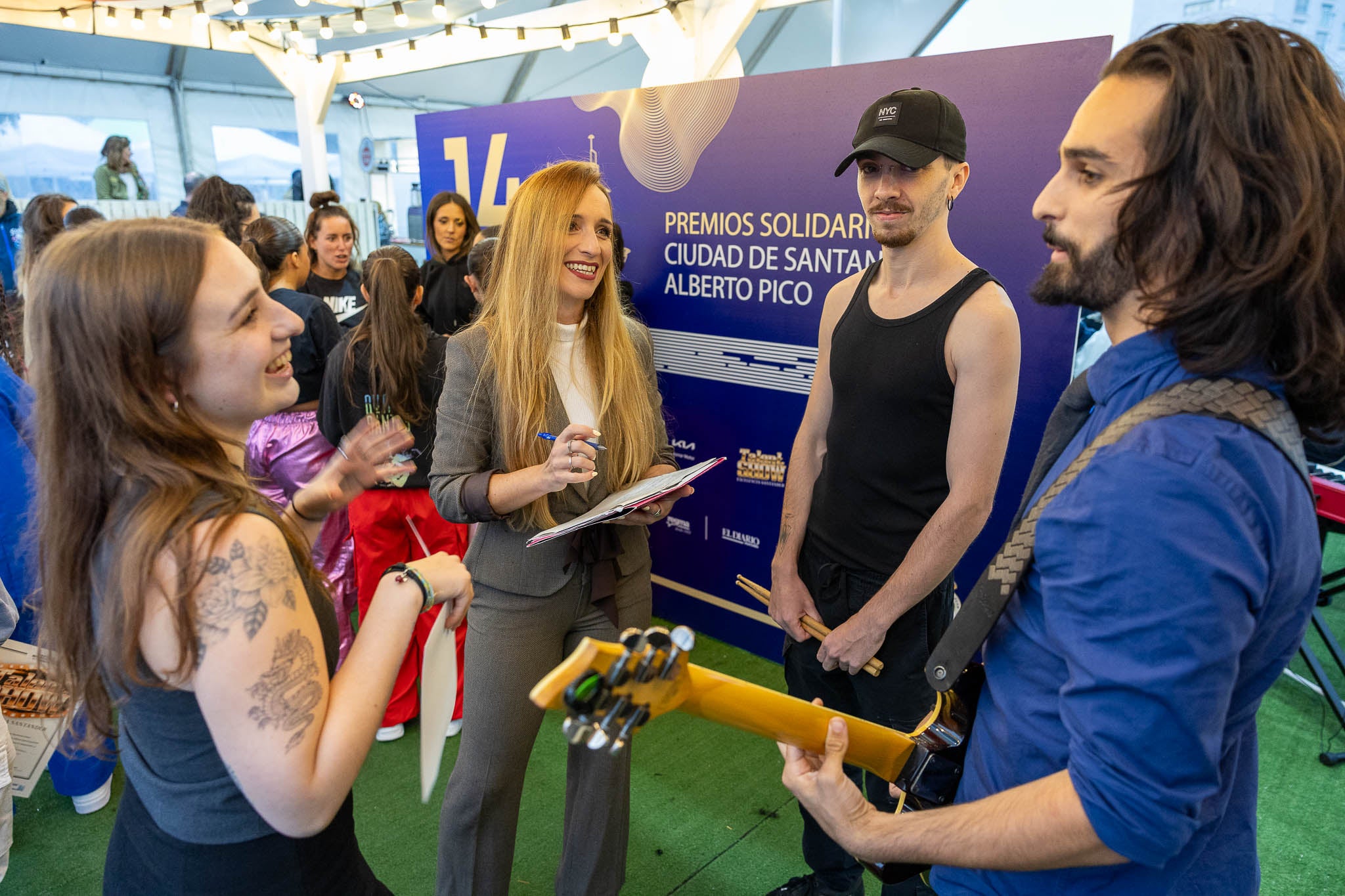 La presentadora del evento, Sheila Izquierdo, charla con una de las bandas de música participantes.