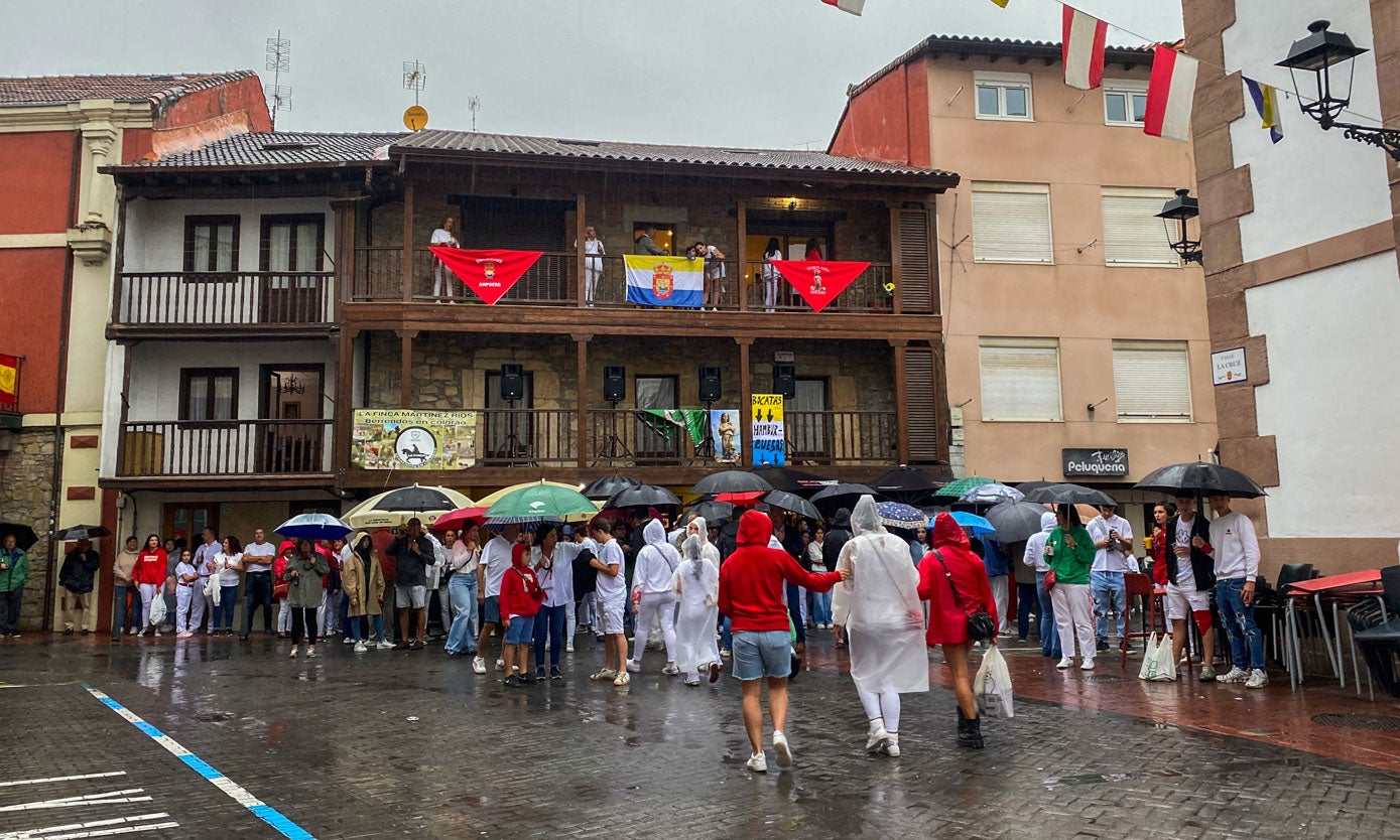 Los presentes se guarecieron de la lluvia con paraguas y chubasqueros.