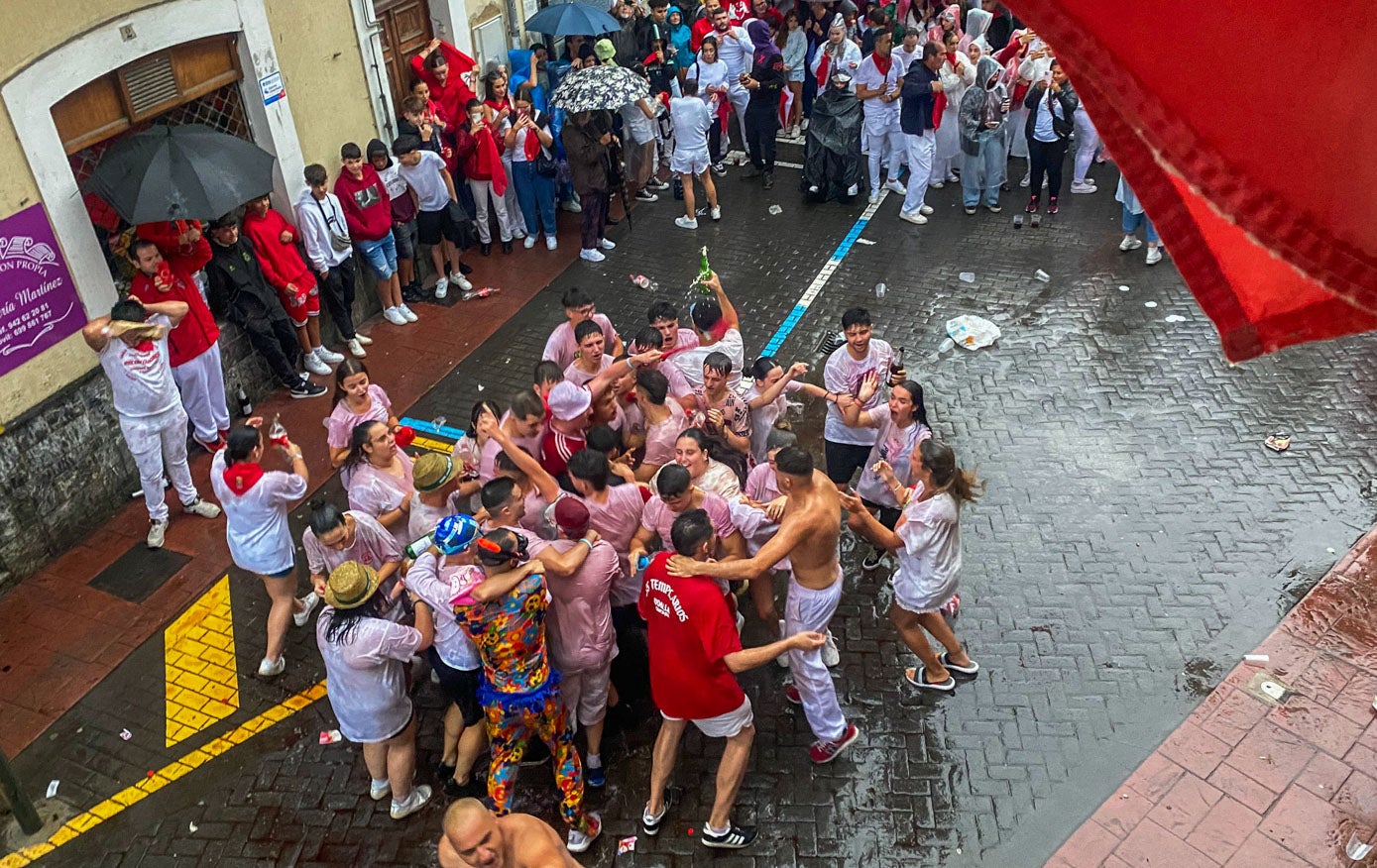 El tradicional baño de vino tras el chupinazo.