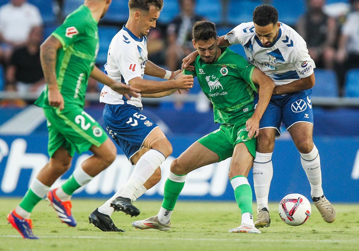 Andrés Martín protege la pelota ante dos jugadores del Tenerife.