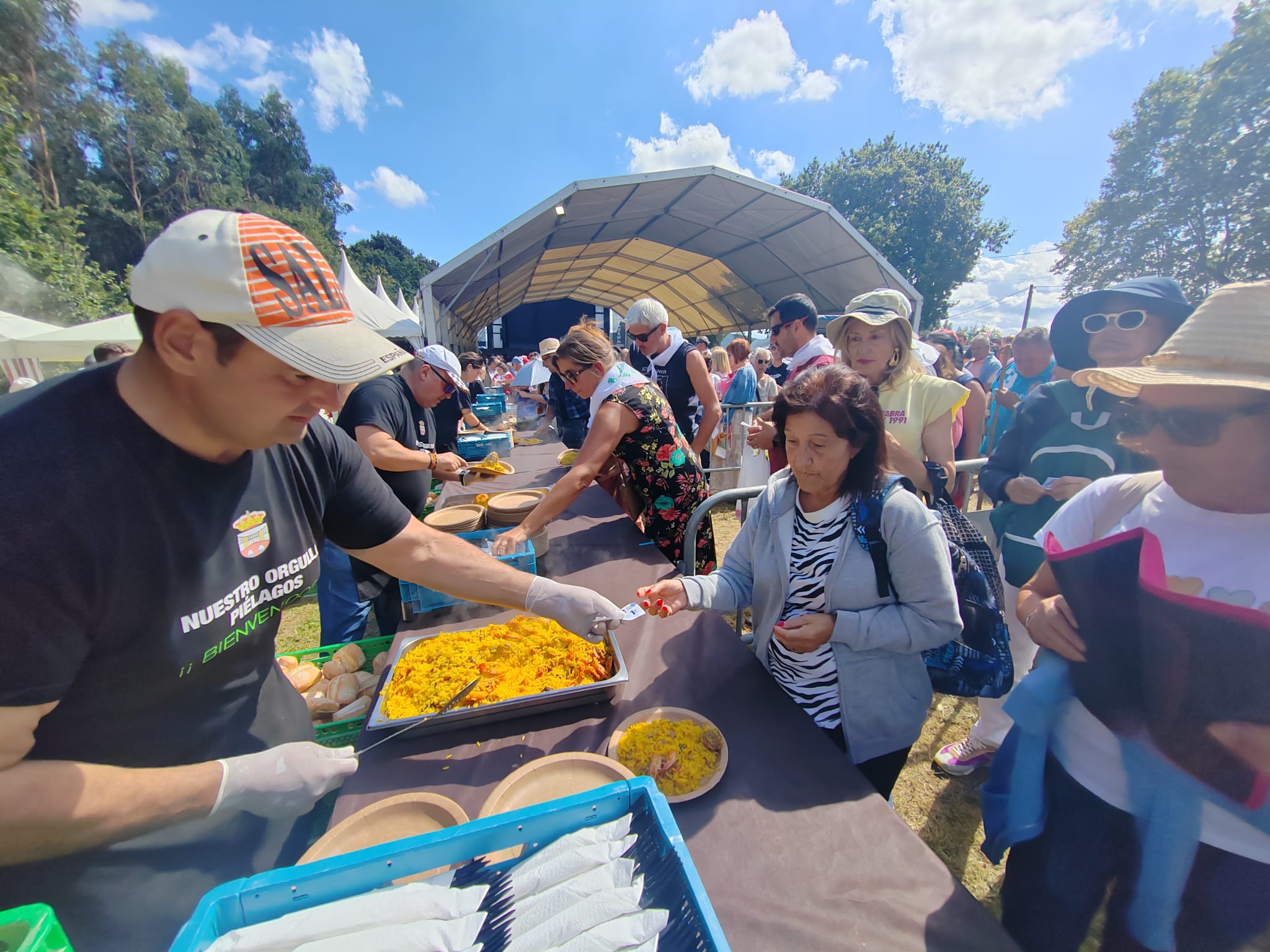 Largas colas para degustar la paella popular en la pradera del Santuario