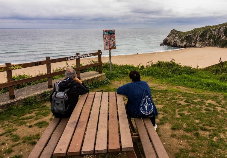 Una pareja disfruta delas vistas de la playa deUsgo, en Miengo.