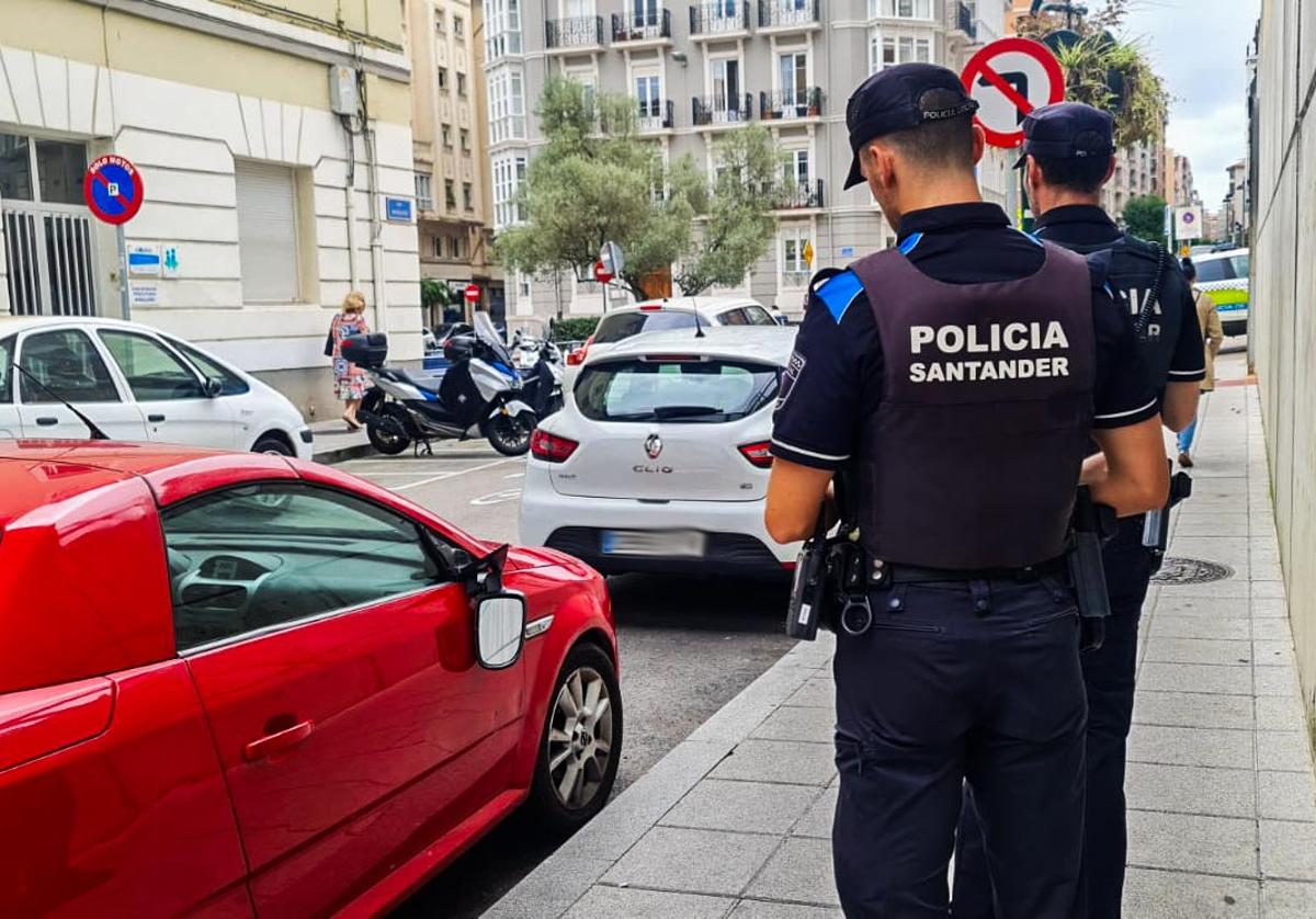 Dos agentes toman nota del acto vandálico.