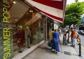 Una familia observa el escaparate de una tienda de Hernán Cortés.