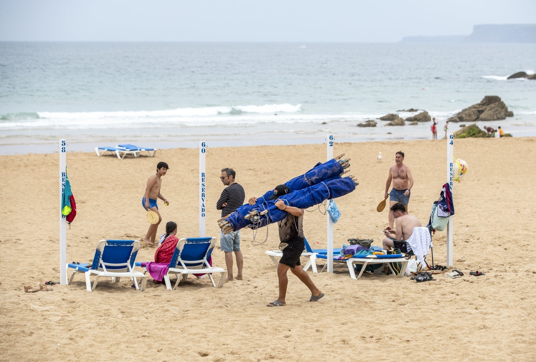 Varios bañistas recogen sus bártulos en la Primera playa de El Sardinero ante la amenaza de lluvia.