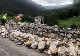 Muro de mampostería que se está construyendo en la entrada al pueblo de El Barcenal.