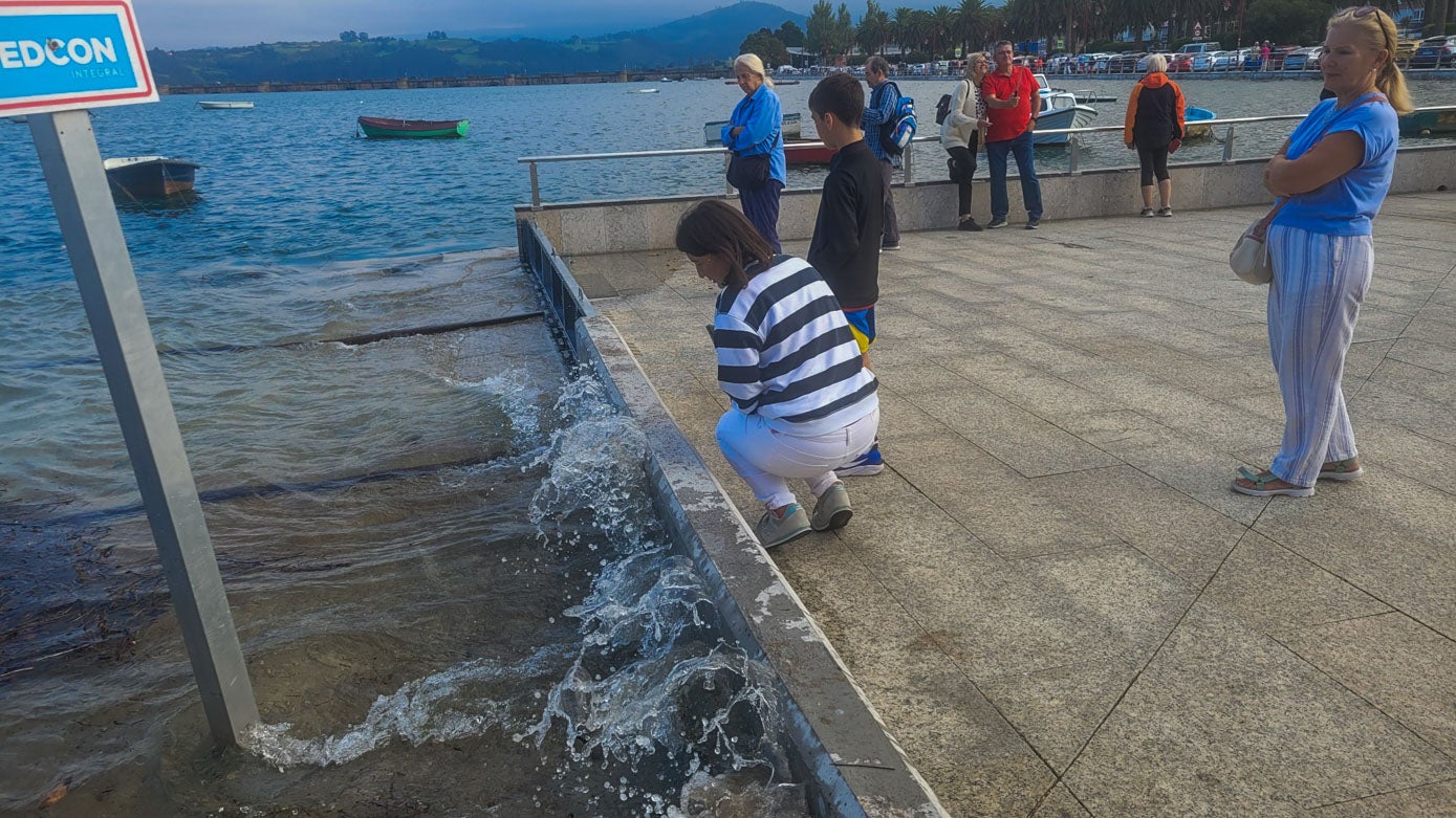 Algunos viandantes se acercaban al agua en San Vicente de la Barquera.