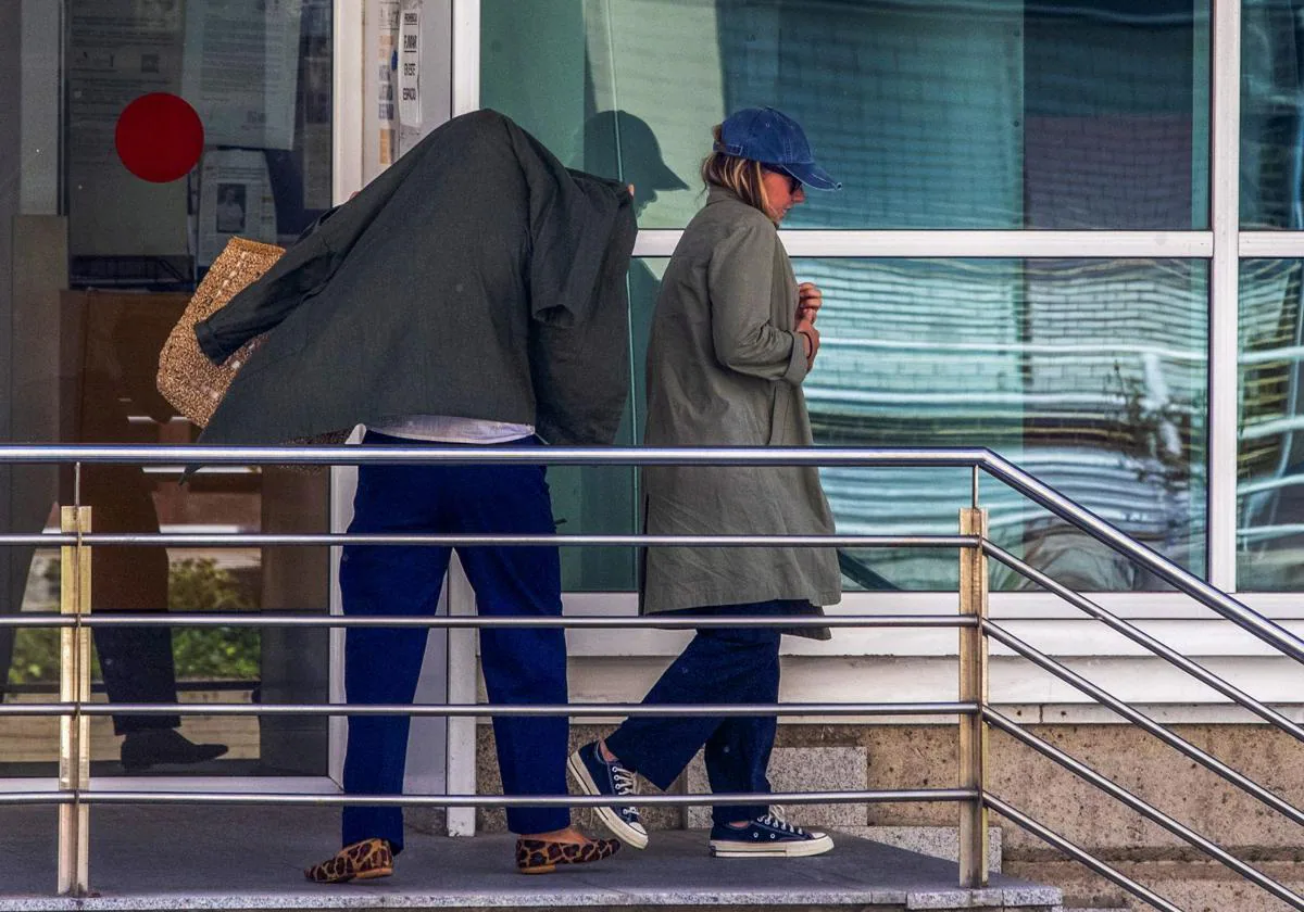 Beatriz del Río, la mujer del funcionario, se cubre con una chaqueta a la salida del Juzgado en compañía de su hija Cecilia, con gafas y una gorra.