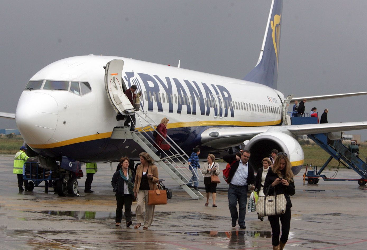 Pasajeros del primer vuelo de la ruta Madrid-Santander de Ryanair desembarcan del avión.