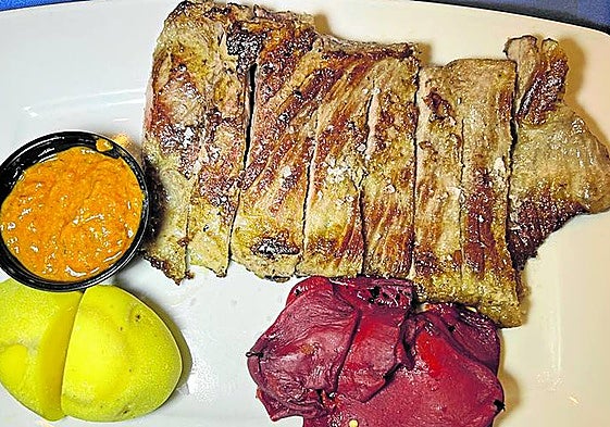 Secreto de cerdo ibérico con papas saladas, pimientos y chimichurri casero.