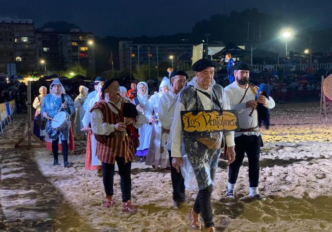 Los participantes en la recreación se protegieron de la lluvia.