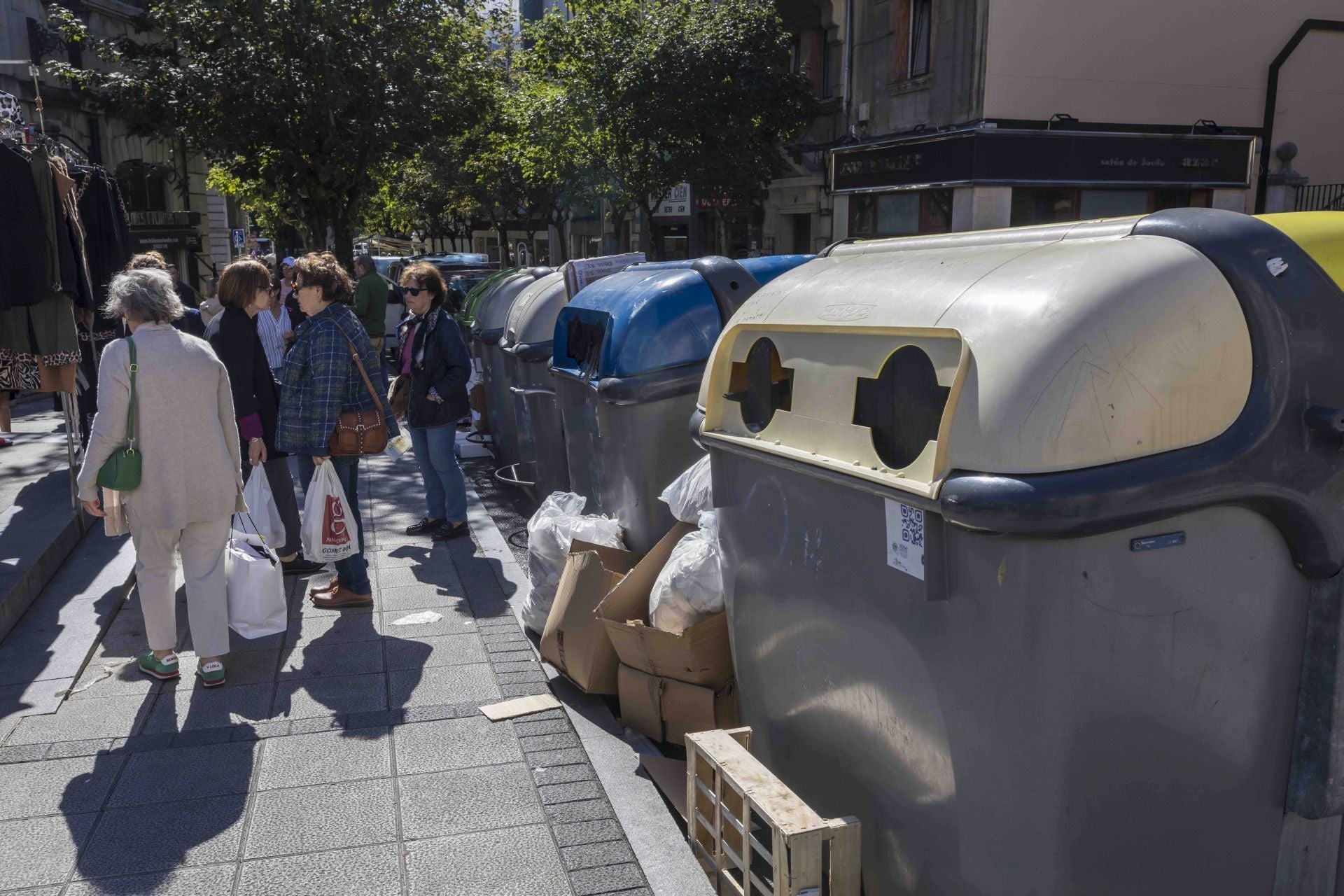 Varios contenedores con basura a su alrededor en la plaza de la Esperanza.