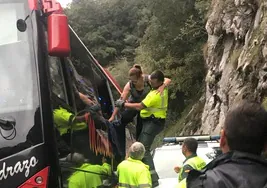 Un guardia Civil ayuda a salir a una de las pasajeras