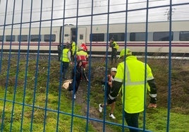 Los pasajeros del Alvia que partió a primera hora de Santander, ayudados por los bomberos y la policía para deslojar el convoy.