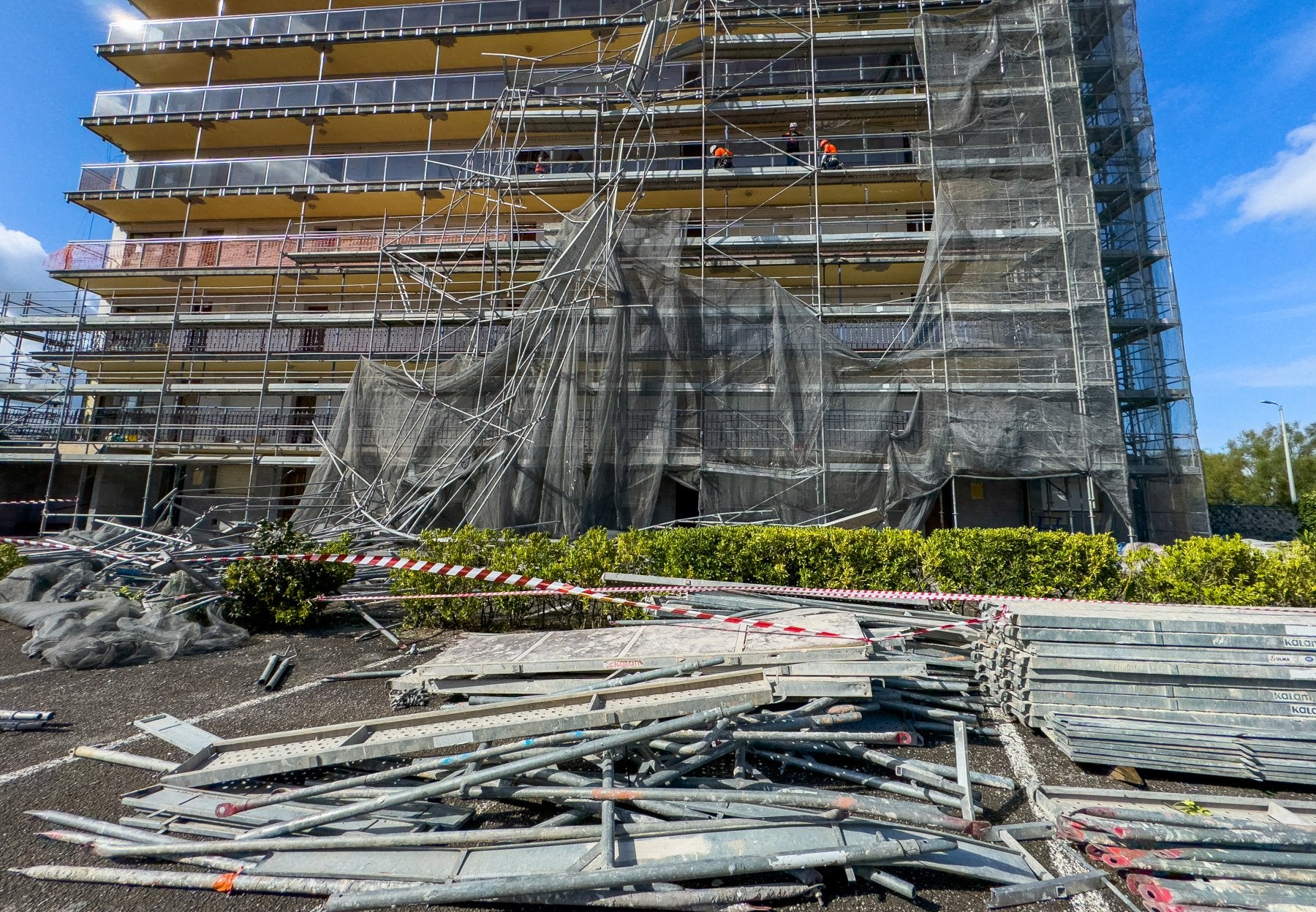Los restos del andamio, sobre el patio del edificio, mientras que varios obreros trabajan en la fachada.