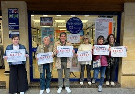 Los trabajadores de la Administración Número 1 'Doña Amalia', posan junto con una cliente con los carteles del premio, esta mañana.