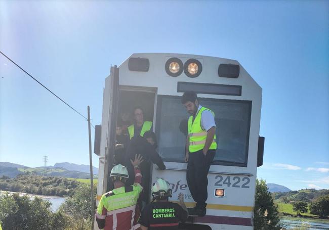 Operarios de Renfe, bomberos y guardias civiles ayudan a los pasajeros a salir del tren