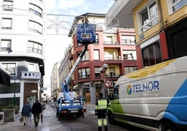 Operarios colocan las primeras luces navideñas, este miércoles, en la calle Mártires de Torrelavega.