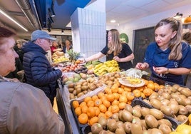 Los clientes hacen cola ante el expositor de Frutas Isabel.