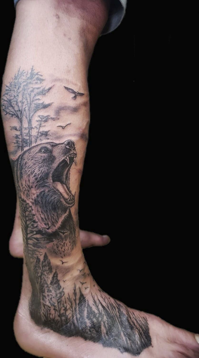 Tatuaje de David Pico en el que se aprecia un oso, aves y un bosque