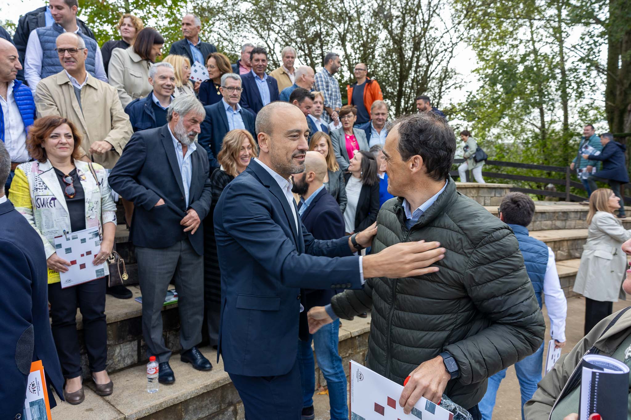 Javier López Estrada saluda a su colega de Alfoz de Lloredo, el independiente Enrique Bretones.