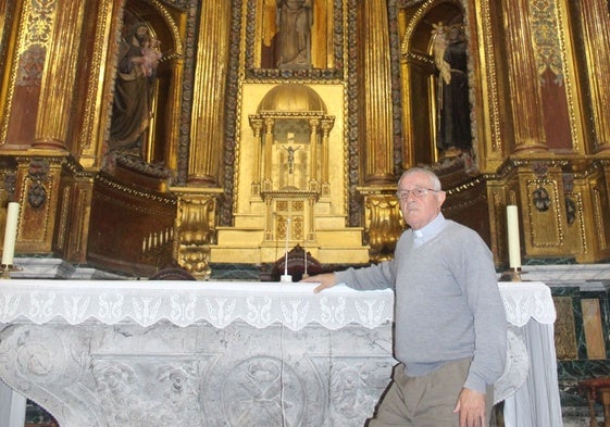 El párroco de Liérganes junto al altar y el retablo que le tiene muy preocupado.