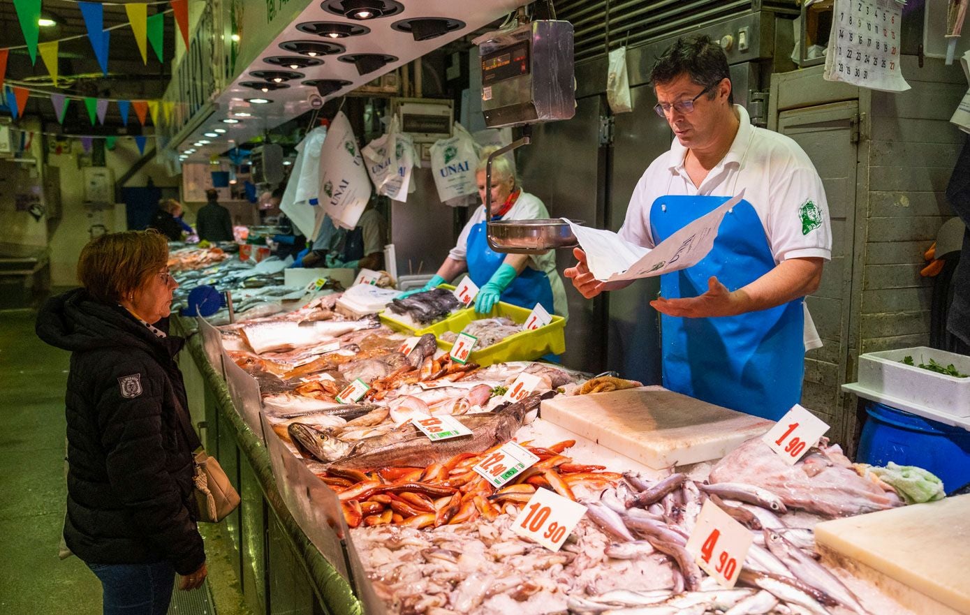 Unai, en su puesto del Mercado de la Esperanza, se prepara para atender el pedido de una clienta