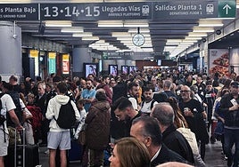 Los pasajeros esperan, este domingo, en Atocha ante el caos ferroviario en Madrid.