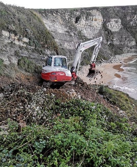 Maquinaria pesada trabajando en el acantilado de Langre.