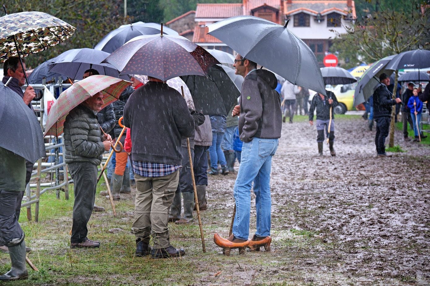 Un hombre lleva albarcas para protegerse del barro.