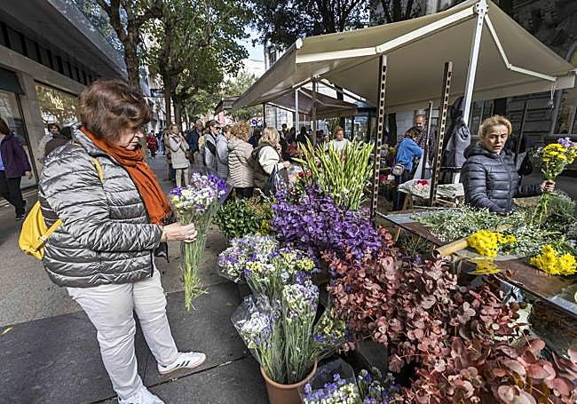 Una mujer coge uno de los ramos preparados para la ocasión.
