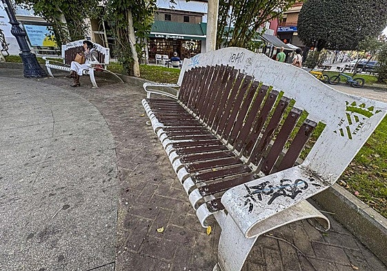 Uno de los bancos de la plaza José María González Trevilla, en Torrelavega, que están grafiteados y en mal estado.