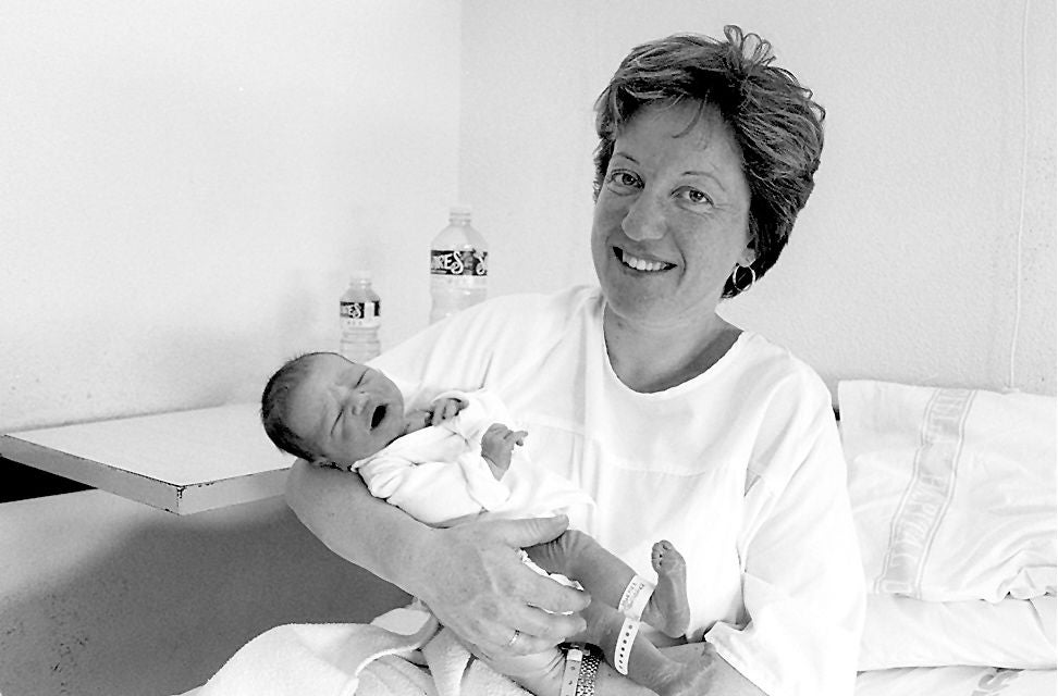 Una madre posa junto a su bebé, recién nacido, tras dar a luz de urgencia en el hospital.