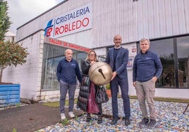 Vicente Robledo, Cristina García Viñas, Javier López Estrada y Alejandro Robledo sostienen un cascabel gigante diseñado artesanalmente, este miércoles, durante la visita del alcalde y la concejala al taller de ambos comerciantes.