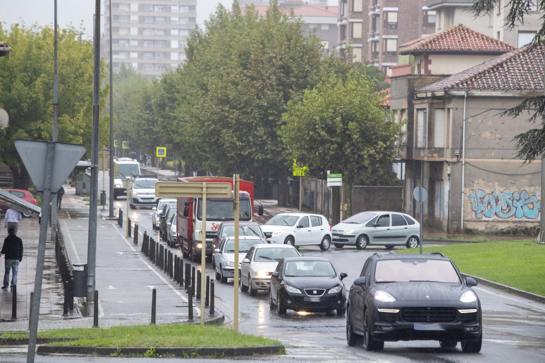 Vehículos circulan lentamente por el Paseo de Julio Hauzeur y la rotonda ovalada, junto al IES Miguel Herrero, en Torrelavega.