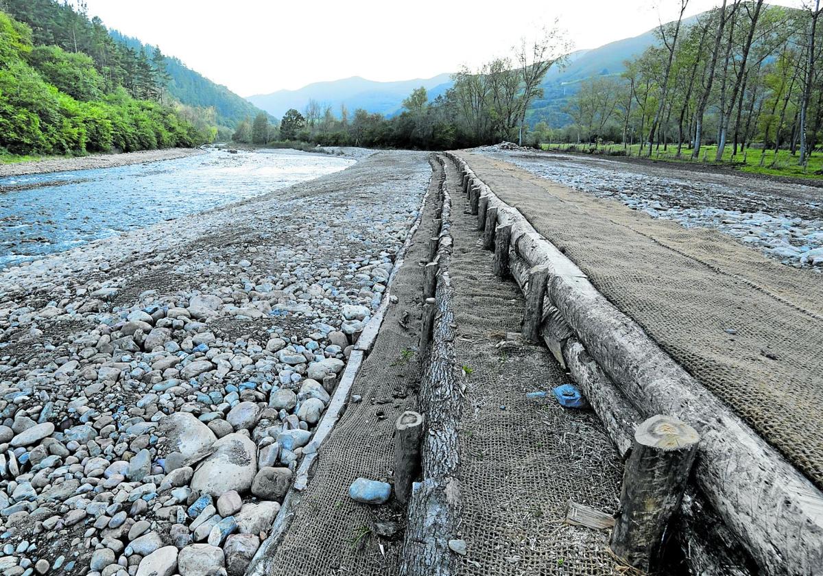 Trabajos de acondicionamiento en el cauce del río Saja, con taludes tendidos.