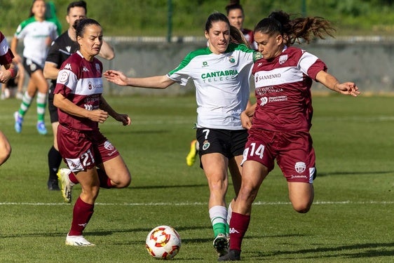 Sandra, del Racing, pelea por el balón con dos rivales del Villalonga.