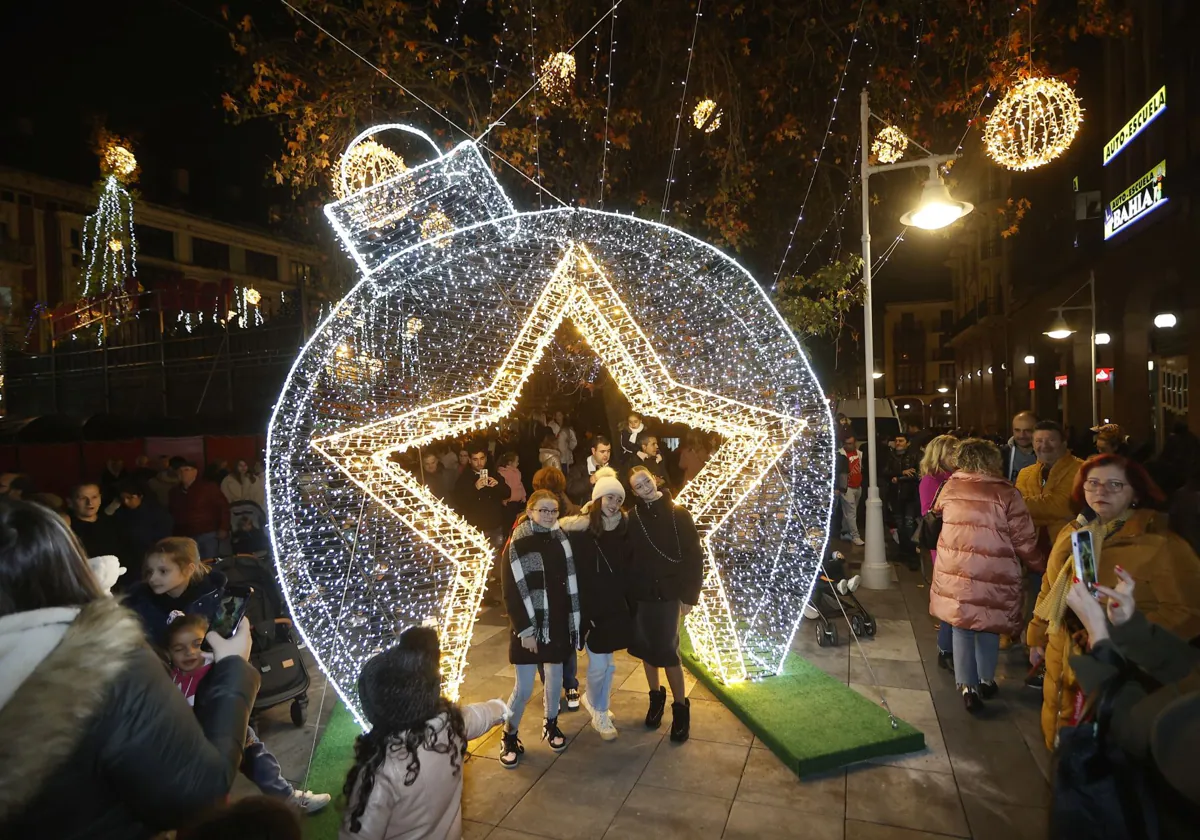 Vecinos posan en uno de los atractivos iluminados de las fiestas navideñas, el año pasado, en la Plaza Mayor de Torrelavega.