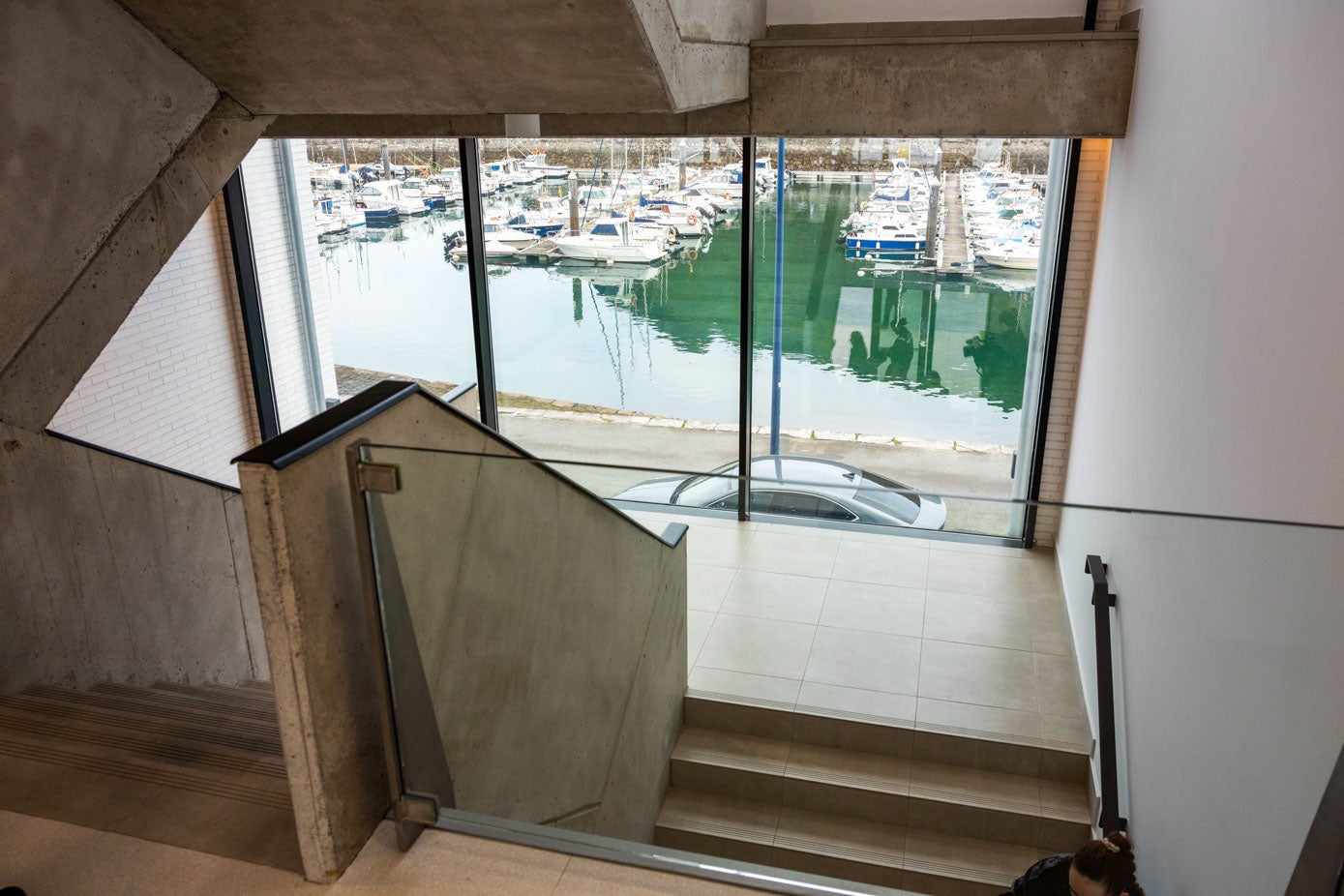 La escalera que comunica las tres plantas del edificio dispone de una gran cristalera con vistas al puerto.