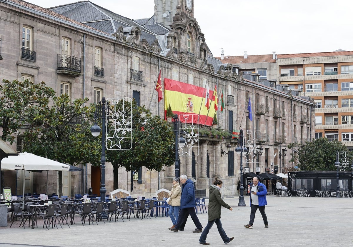 Vecinos caminan frente al Palacio municipal de Torrelavega, este martes, en el Bulevar Demetrio Herrero.