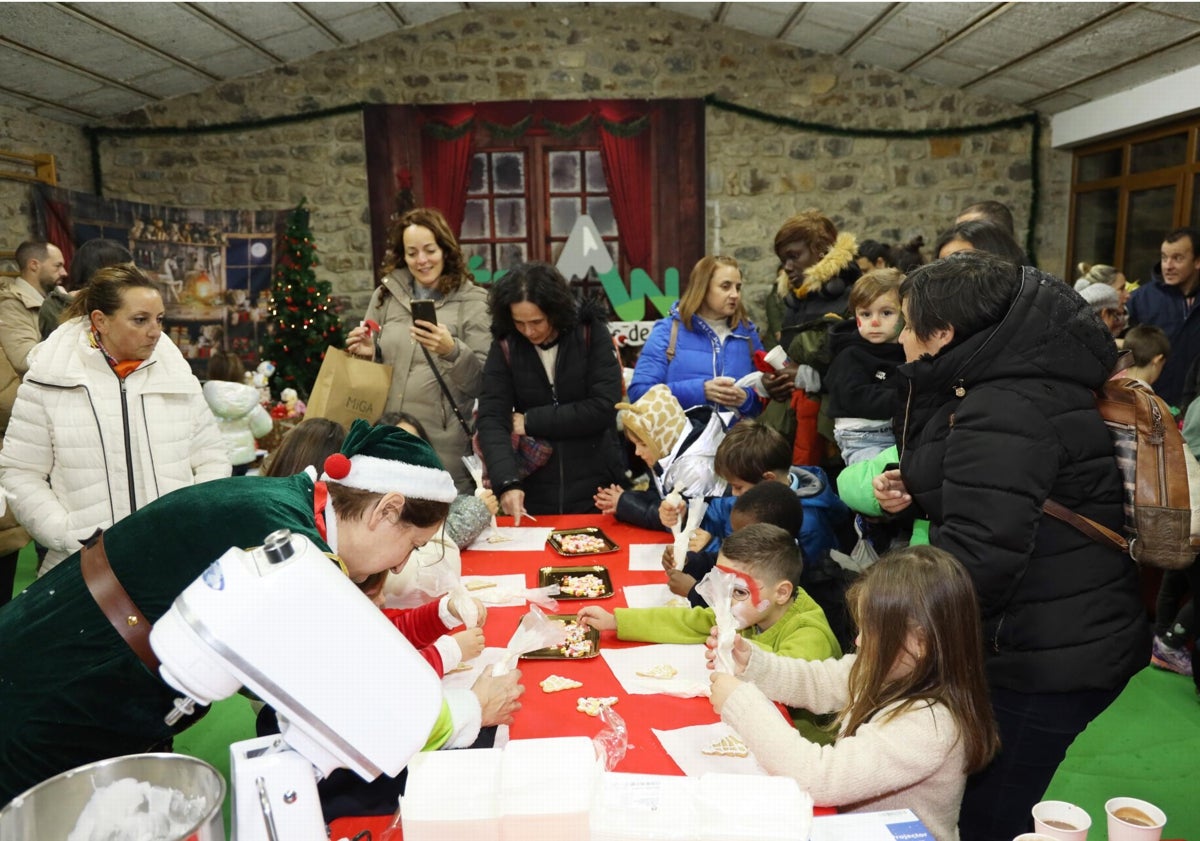 Imagen principal - Actividades realizadas en el salón de la antigua Obra Pía, y dos hermanos se fotografían con Papa Noel después de entregar sus cartas