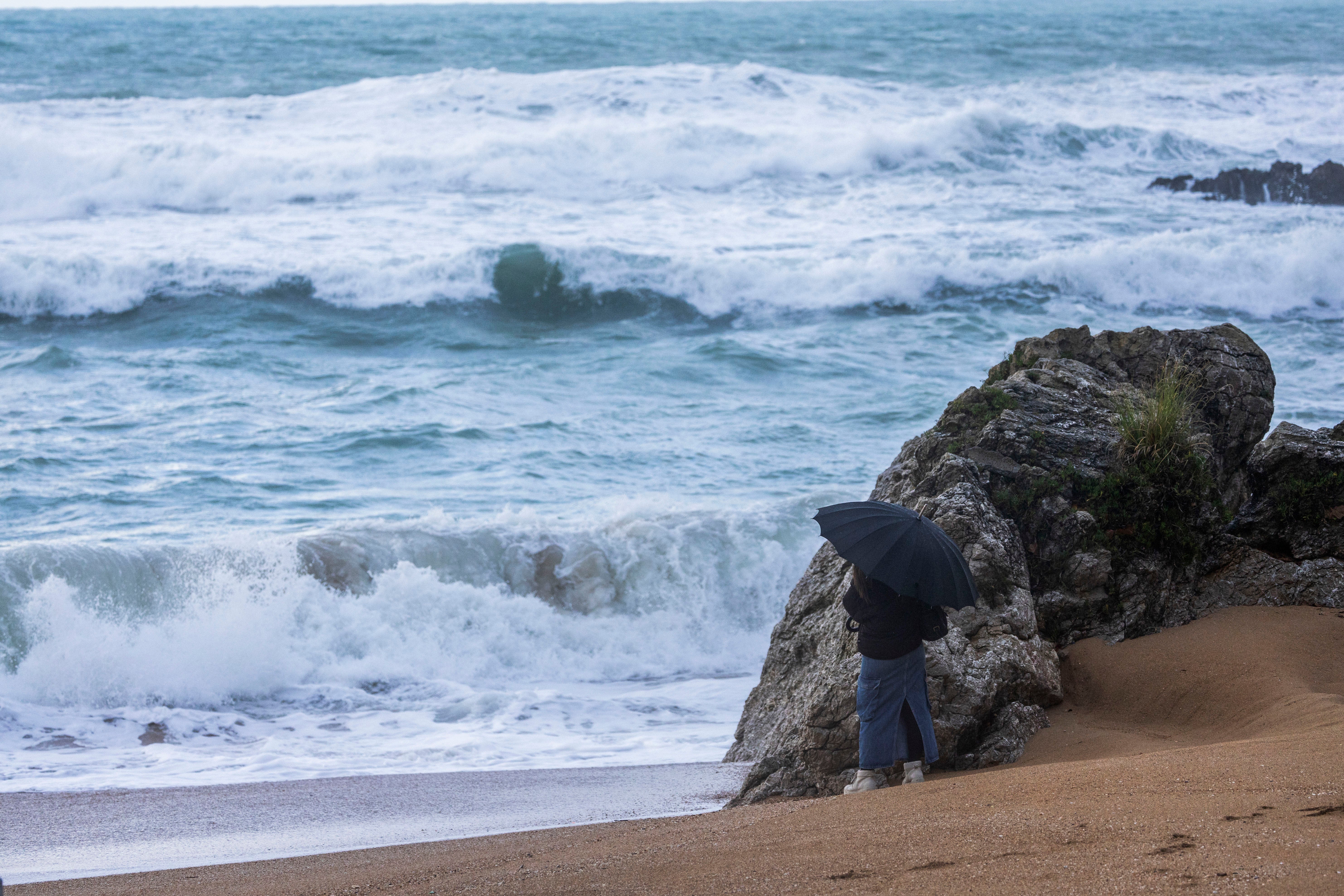 Una mujer contempla las grandes olas en las playas del Sardinero